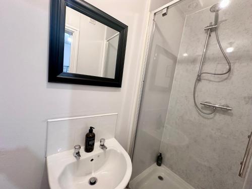 biała łazienka z umywalką i prysznicem w obiekcie BOOT LANE STUDIO APARTMENT w mieście Blaenavon