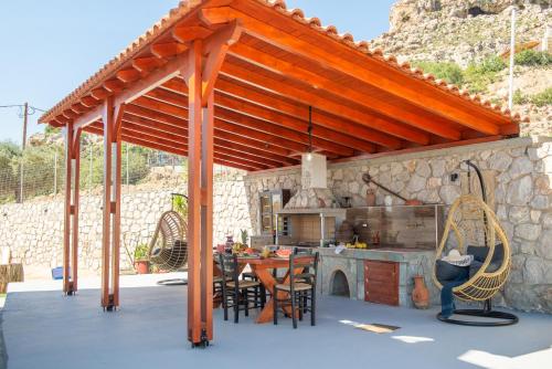 a wooden pergola in a kitchen with a table at Blue Bay Villas , Ground Floor in Archangelos