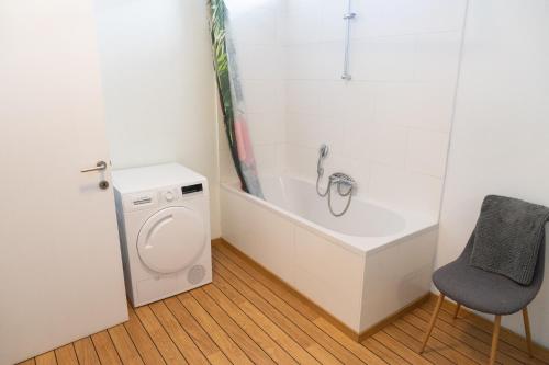a bathroom with a tub and a toilet and a chair at LE PARADIS ATHOIS in Ath