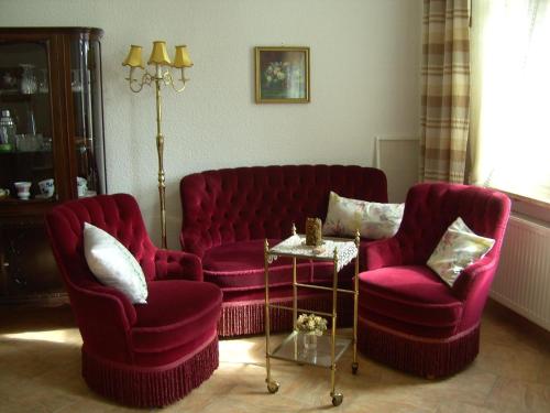 una sala de estar con 2 sillas rojas y una mesa. en Ferienwohnung für 5 Personen 1 Kind ca 115 qm in Bad Wilsnack, Brandenburg Landkreis Prignitz, 