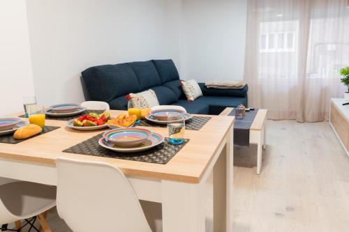 een woonkamer met een tafel met eten erop bij Apartamento 'Koala21', Nuevo, Céntrico y con opción de parking in Jaén