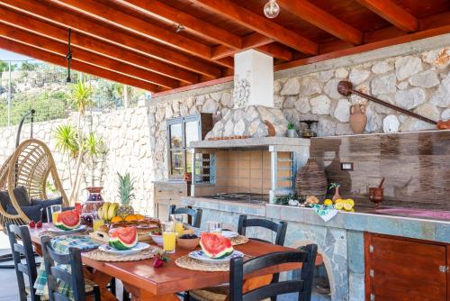 una cucina con tavolo e frutta di Blue Bay Villas , Ground Floor a Archangelos
