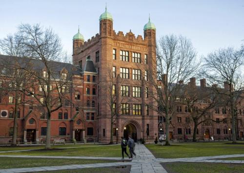 a large brick building with people walking in front of it at Downtown New Haven by Yale & Little Italy - AO Destinations in New Haven