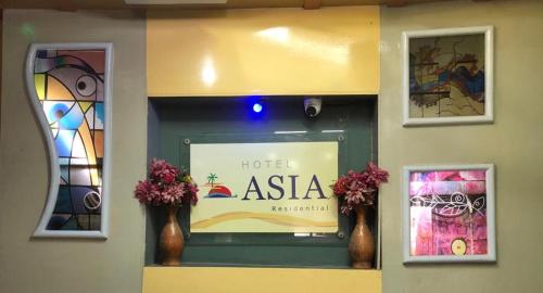 a hotel asia sign in a window with vases at Hotel Asia in Cox's Bazar