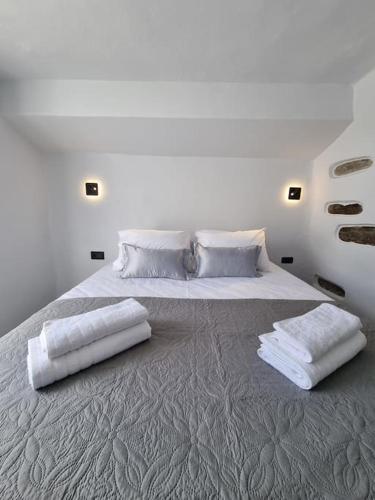 a large white bed with two pillows on it at Màrgaros House Tinos in Triandáros