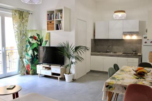 una cucina e un soggiorno con tavolo e TV di Casa Artesano, appartamento San Michele a Trapani