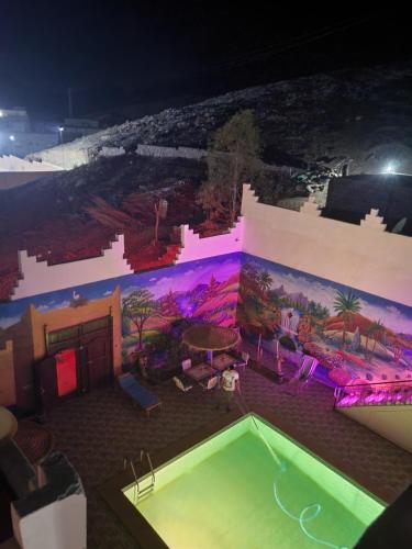 una piscina en un edificio con una pintura en la pared en Dar Ilyana, en Aït Tiourhza