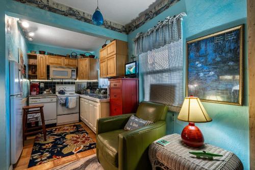 a living room with a green couch and a kitchen at Blue Bell Apartment Hotel in Fort Lauderdale