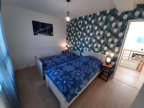 une chambre avec un lit avec une couette bleue dans l'établissement Maison neuve tout équipée, à Tourville-sur-Odon