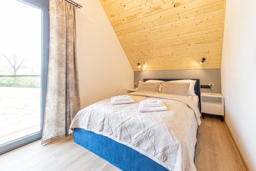 a bedroom with a bed with a wooden ceiling at Niebieska Turnia in Poronin