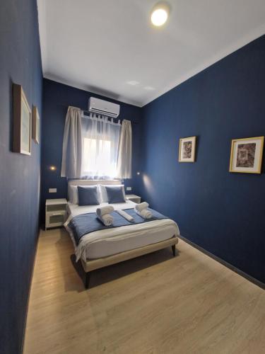 1 dormitorio con 1 cama con pared azul en KORZO SUITES SENGLEA WATERFRONT en Senglea