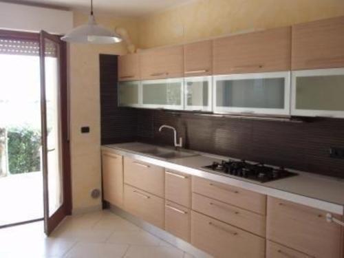 una cucina con armadi in legno e lavandino di Ferienwohnung für 3 Personen ca 50 qm in Pineto, Adriaküste Italien Mittlere Italienische Adriaküste a Pineto