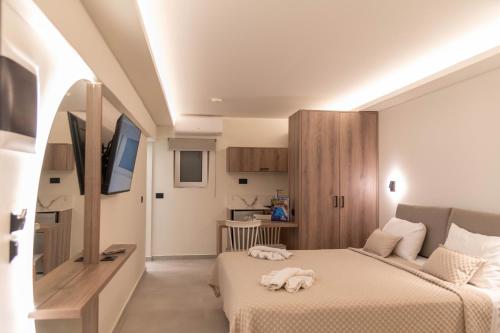um quarto de hotel com duas camas e uma televisão em Missiria Apartments em Rethymno Town