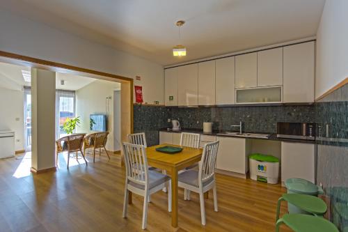 una cucina e una sala da pranzo con tavolo e sedie in legno di 714 Mugnano House Aveleda a Vila do Conde
