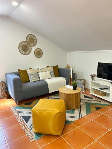 a living room with a couch and a coffee table at Refúgio do Seixal in Seixal