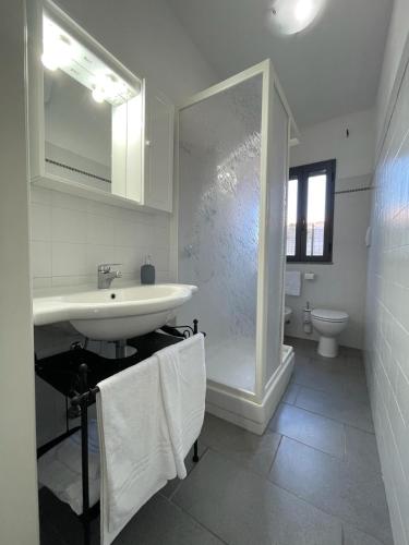 a white bathroom with a sink and a toilet at Casa Porto San Rocco in Marina di Grosseto