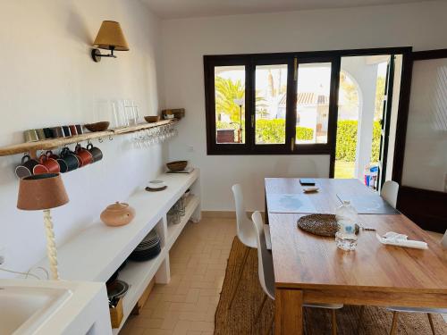 uma cozinha com uma mesa de madeira e uma sala de jantar em Minorque maison 4 chambres - licence touristique em Son Bou