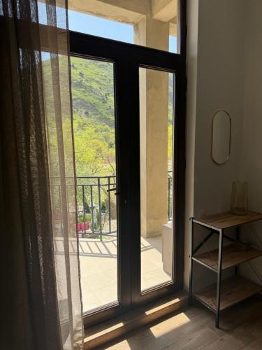 an open glass door with a view of a balcony at Mtskheta apartment 17 in Mtskheta