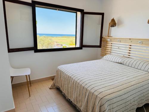 um quarto com uma cama e uma janela em Minorque maison 4 chambres - licence touristique em Son Bou