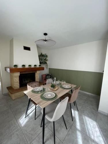 a dining room with a table and chairs and a fireplace at Aux Alcôves du Spa in La Rothière