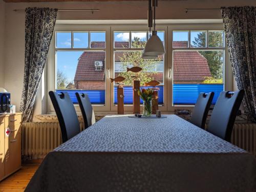 a dining room with a table and chairs and a window at Voslapper Seeluft in Wilhelmshaven