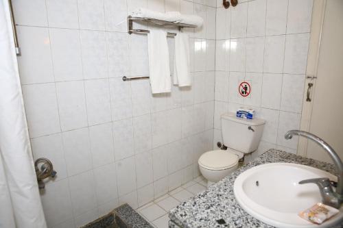 a white bathroom with a toilet and a sink at Rezeiky Hotel & Camp in Luxor