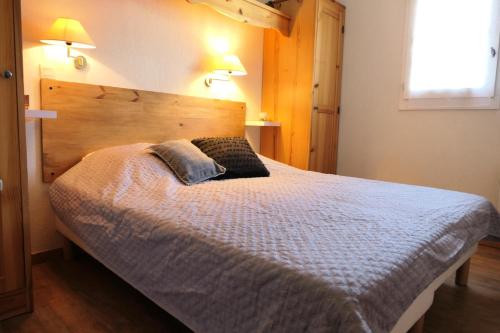 une chambre avec un grand lit avec une tête de lit en bois dans l'établissement Résidence Le Grand Panorama - Grand Panorama 411 MAE-5270, à Saint-Gervais-les-Bains