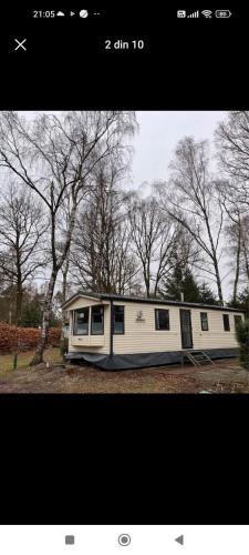 a white trailer parked in a field with trees at Bungalow WILLERBY in Maasmechelen