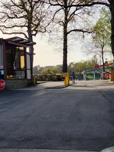 an empty parking lot with a building and trees at Bungalow WILLERBY in Maasmechelen