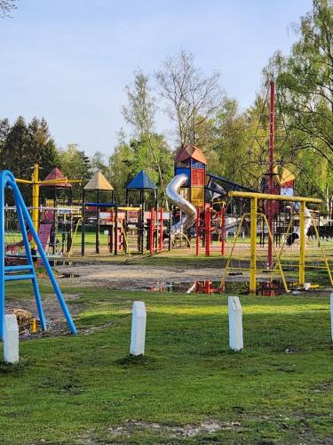 a park with a playground with slides and swings at Bungalow WILLERBY in Maasmechelen