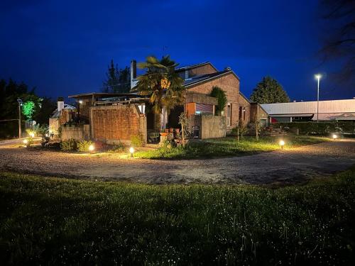 una casa di notte con luci sul vialetto di Villa Yemaya - camera con bagno privato a Casarsa della Delizia