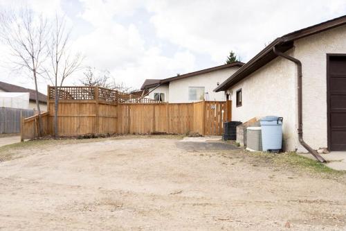 a wooden fence in front of a house at Home Away from Home - Guest Suite 1 in Red Deer