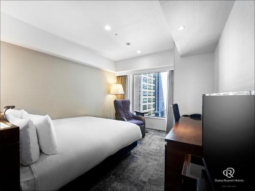 a hotel room with a bed and a desk and a window at Daiwa Roynet Hotel Nishi-Shinjuku PREMIER in Tokyo