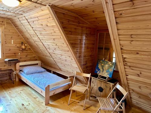 a bedroom with a bed in a log cabin at Leśniczówka in Rządza