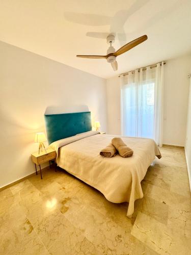 a bedroom with a large bed with a blue headboard at Apartamento Vacacional Sol y Mar in Manilva