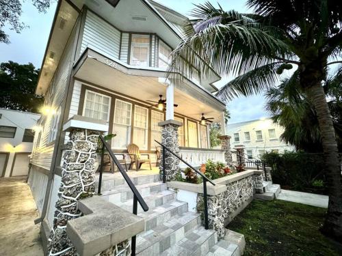 a house with a palm tree next to a staircase at Brickell + Wynwood Wonderland: Spacious 6BR Home in Miami