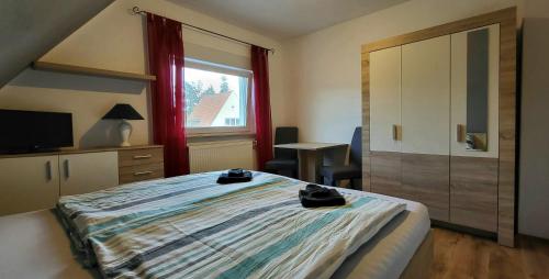 um quarto com uma cama, uma secretária e uma janela em Privates Doppelzimmer bei der Weser-Ems Halle em Oldenburg