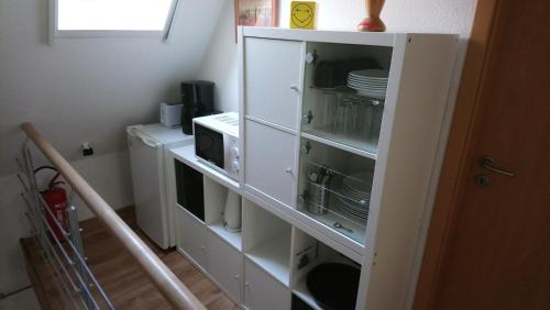 a white cabinet with dishes in it in a kitchen at Privates Doppelzimmer bei der Weser-Ems Halle in Oldenburg