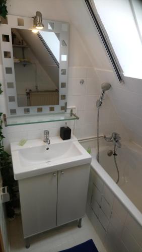 uma casa de banho com um lavatório, um espelho e uma banheira em Privates Doppelzimmer bei der Weser-Ems Halle em Oldenburg