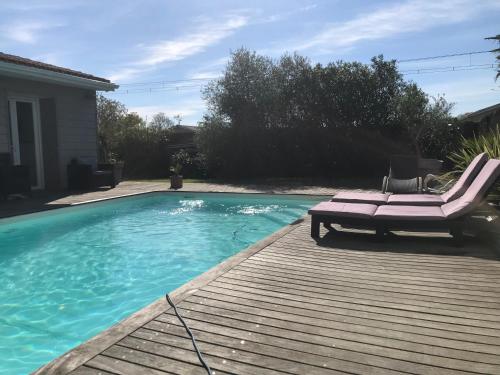 einen Pool mit einer Terrasse und einer Chaiselongue in der Unterkunft La Chartreuse des Vignes in Ludon-Médoc