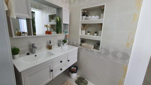 La salle de bains blanche est pourvue d'un lavabo et d'un miroir. dans l'établissement شاليه لحظات, à Āsam
