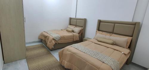 Cette chambre comprend 2 lits et un miroir. dans l'établissement شاليه لحظات, à Āsam