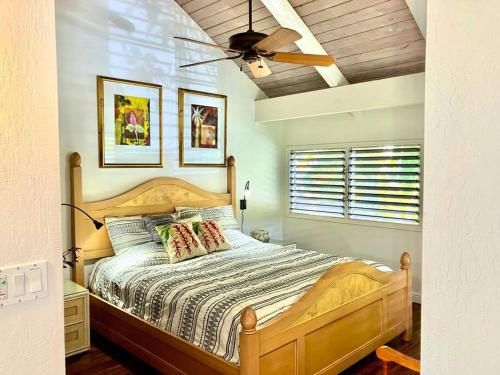 Schlafzimmer mit einem Bett und einem Deckenventilator in der Unterkunft Poipu Crater 14 Peaceful Beach Retreat with AC in Koloa
