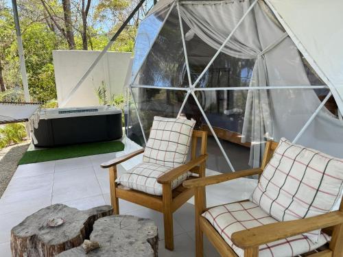 two chairs and a tv in a tent at Amaj Eco Lodge in Sámara