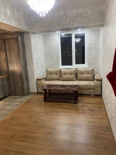 een woonkamer met een bank en een salontafel bij Imran in Bukhara