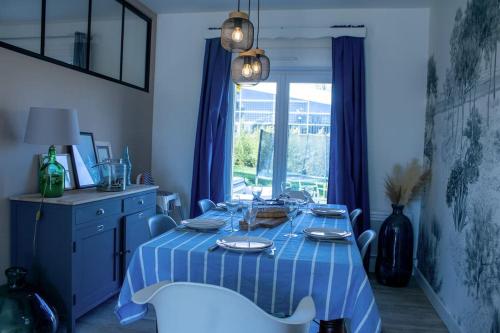 a blue dining room table with a blue and white table cloth at Ar Mervent/Plage à pieds in Crozon