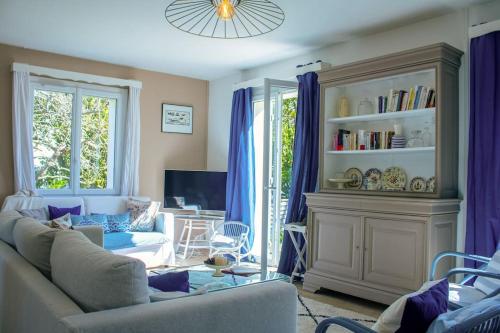 ein Wohnzimmer mit einem Sofa und einem TV in der Unterkunft Ar Mervent/Plage à pieds in Crozon