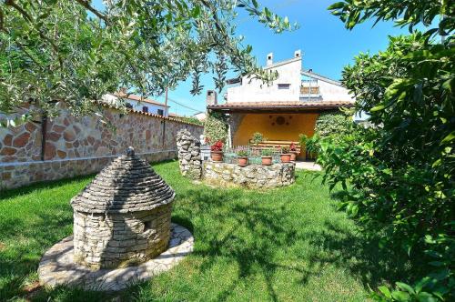 um quintal com uma parede de pedra e uma casa em Ferienwohnung für 8 Personen ca 85 qm in Rovinj, Istrien Istrische Riviera em Rovinj