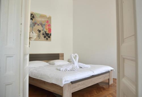 - une chambre dotée d'un lit avec des draps blancs dans l'établissement Apartment Trdinova, à Ljubljana