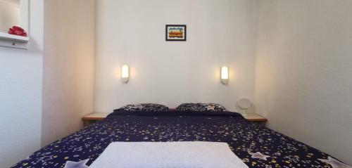 uma cama num pequeno quarto com duas luzes na parede em A & H Rooms + WIFI em Nice